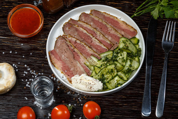 Sliced ​​meat with cucumbers and cottage cheese with fresh herbs. Snack for vodka.