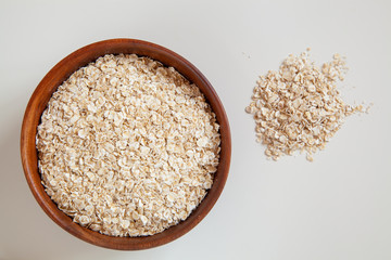 Dry oatmeal in a round wooden plate.