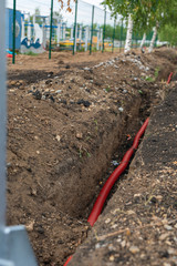 electric cable laying in underground trench. fiber optic cable for fast internet.