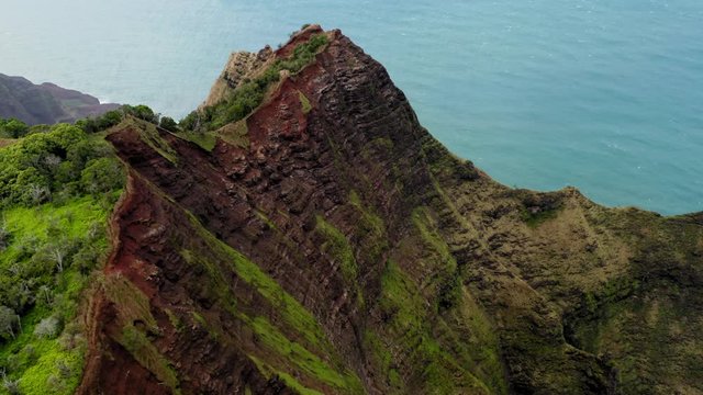 Fantastic top down aerial view over mountain terrain of Hawaii. Unique ribbed slopes and deep narrow gorges are seen from above. The mountainous surface is totally covered with green grass.4K