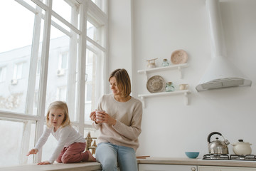 A young mother spends time with her little daughter at home.