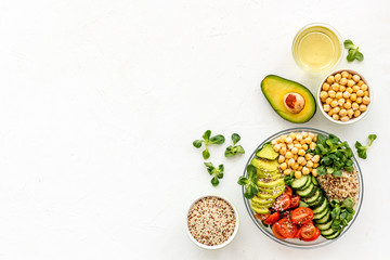 Healthy salad bowl with quinoa, avocado and chickpeas on white background top-down copy space