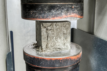 Concrete cube after a compressive strength test. The test sample cracked. - obrazy, fototapety, plakaty