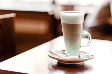 Latte coffee in a large glass stands on a table in a cafe