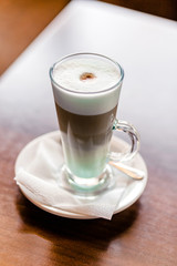 Latte coffee in a large glass stands on a table in a cafe