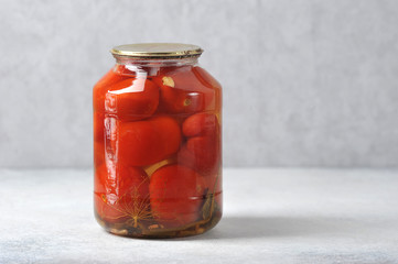 glass jar with iron lid with canned red tomatoes