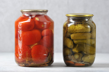 glass jar with an iron lid with canned red tomatoes and cucumbers