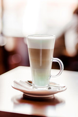 Latte coffee in a large glass stands on a table in a cafe