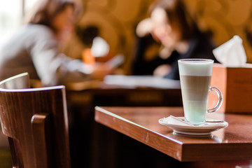 Latte coffee in a large glass stands on a table in a cafe