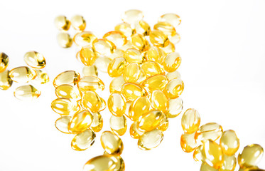 Yellow fish oil capsules on a white background