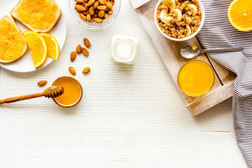 Homemade granola for morning meal. White desk with taost and fruits top-down frame copy space