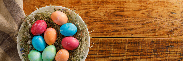 Fototapeta na wymiar Still life of easter eggs in a bird's nest on a wooden background. Rustic. Easter celebration concept. Copy space. Flat lay. Banner.