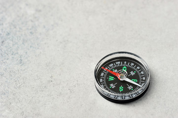 compass with a red magnetic arrow on a gray background with space for text