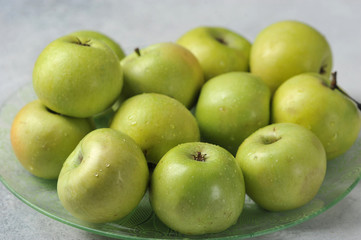 green whole juicy apples on a plate