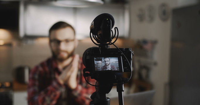 Close-up professional camera filming happy young social media blogger man, making videos for vlog slow motion.