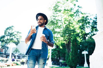 Content male watching mobile phone during stroll