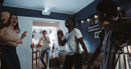 Cheerful multiethnic young college students having epic fun dancing together at party celebrating holidays slow motion.