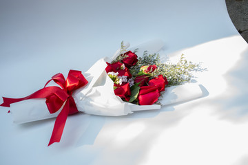 Hand holding a bouquet of beautiful red roses On a white background to congratulate and give as a gift instead of love.concept