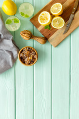Make lemonade. Drink in bottle near utensil on green wooden background top-down copy space