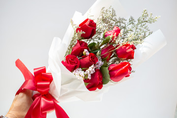 Hand holding a bouquet of beautiful red roses On a white background to congratulate and give as a gift instead of love.concept
