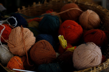Coats with colored wool in a basket