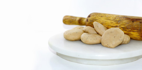 Rolling wheat flour dough into round dumplings to make puri or chapati, an Indian bread