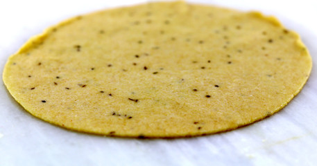 Rolling wheat flour dough into round dumplings to make puri or chapati, an Indian bread
