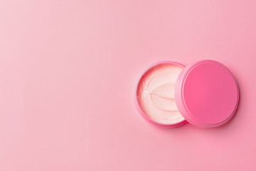 Jar of cosmetic cream on color background