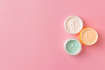 Obraz na płótnie Canvas Jars of cosmetic cream on color background