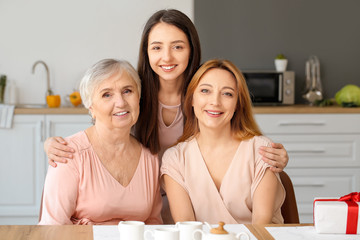 Mature woman with her adult daughter and mother spending time together at home