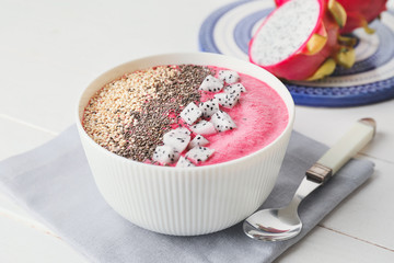 Bowl with dragon fruit smoothie on table
