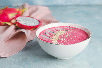 Bowl with dragon fruit smoothie on color background