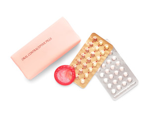Contraceptive pills and condom on white background