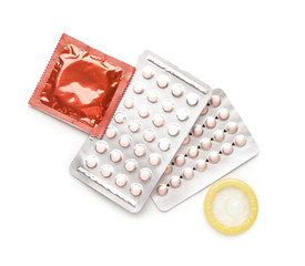 Contraceptive pills and condoms on white background
