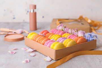 Gift box with tasty macarons on table