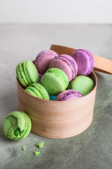 Gift box with tasty macarons on color background