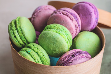 Gift box with tasty macarons on color background, closeup