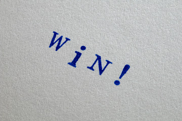 a win word stamped on a piece of paper.