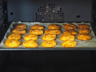 Home cooking.Raw pumpkin cookies with added raisins before baking in a home kitchen oven.