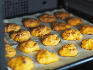 Home cooking. Halloween. Pumpkin cookies with raisins and seasonings in the home kitchen oven.