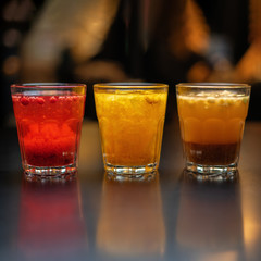 Hot drinks from fruits and berries on a black table against the background of the cafe's interior. Close up.