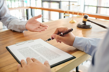 Legal counsel presents to the client a signed contract with gavel and legal law. justice and lawyer...
