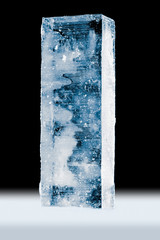 Cold pure translucent ice block, on white surface, isolated on black background.