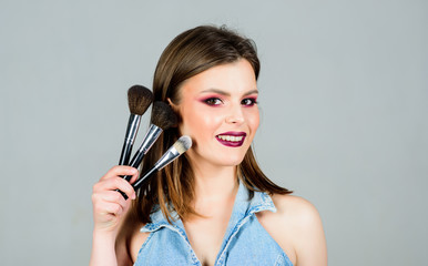 Fototapeta premium makeup in modern fashion style. skincare cosmetics. fashion makeup visage. sensual woman with long hair. sexy woman with professional make up brush. beauty hairdresser salon. Lipstick and eyeshadow