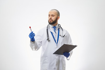 A doctor looking at a coronavirus blood test in his hand. A portrait of an infectious disease physician holding a positive COVID-19 blood sample and a clipboard.