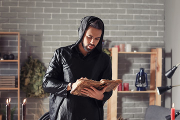 Male alchemist with spell book in laboratory