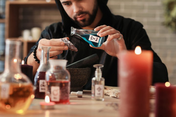Male alchemist making elixir in laboratory