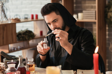 Male alchemist making elixir in laboratory