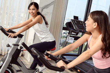 Fototapeta na wymiar Two smiling young woman workout in the gym