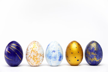 Happy Easter. Five easter eggs trendy colored classic blue, white and golden on blue. Minimal style, top view, flatlay, copy space for text.